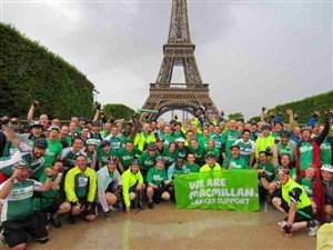 Cyclists in front of Eiffel Tower after London to Paris bike ride for Macmillan