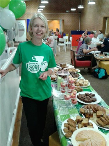 An image of Sue with lots of cakes at her local sports centre
