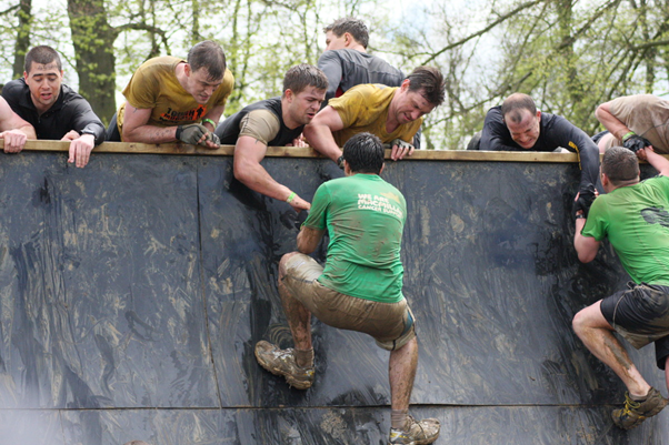 People climbing over an obstacle.
