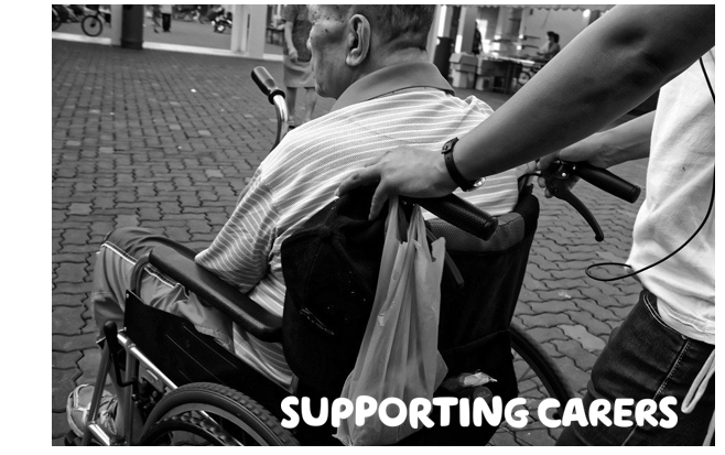  "Supporting carers" written in white over a black and white photograph of someone pushing someone else in a wheelchair facing away from the camera
