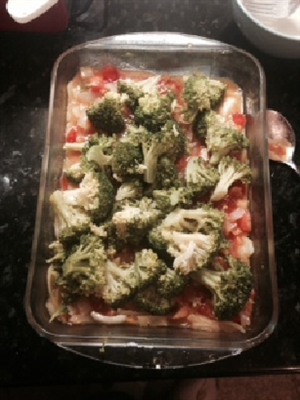 Image shows all the ingredients for Broccoli Mornay in a glass dish ready for cooking.