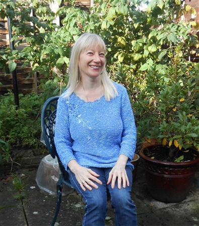 Irene, a cancer information reviewer, sits in her garden at home