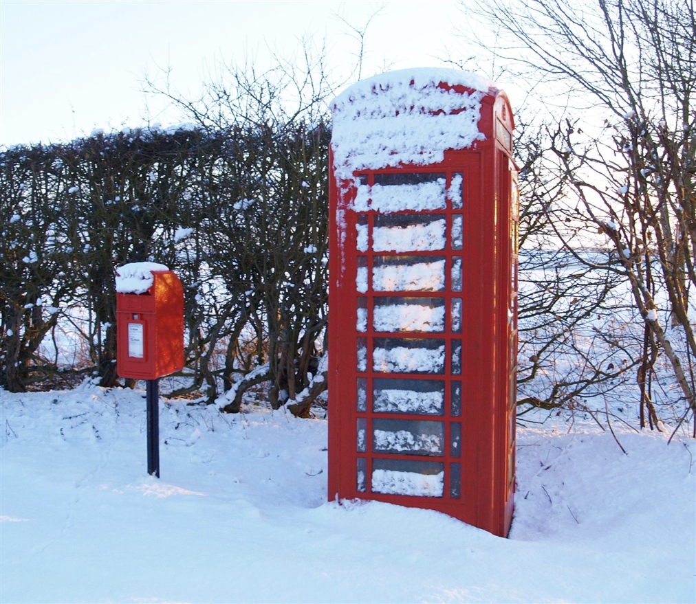 A snowy postbox and red telephone box. 