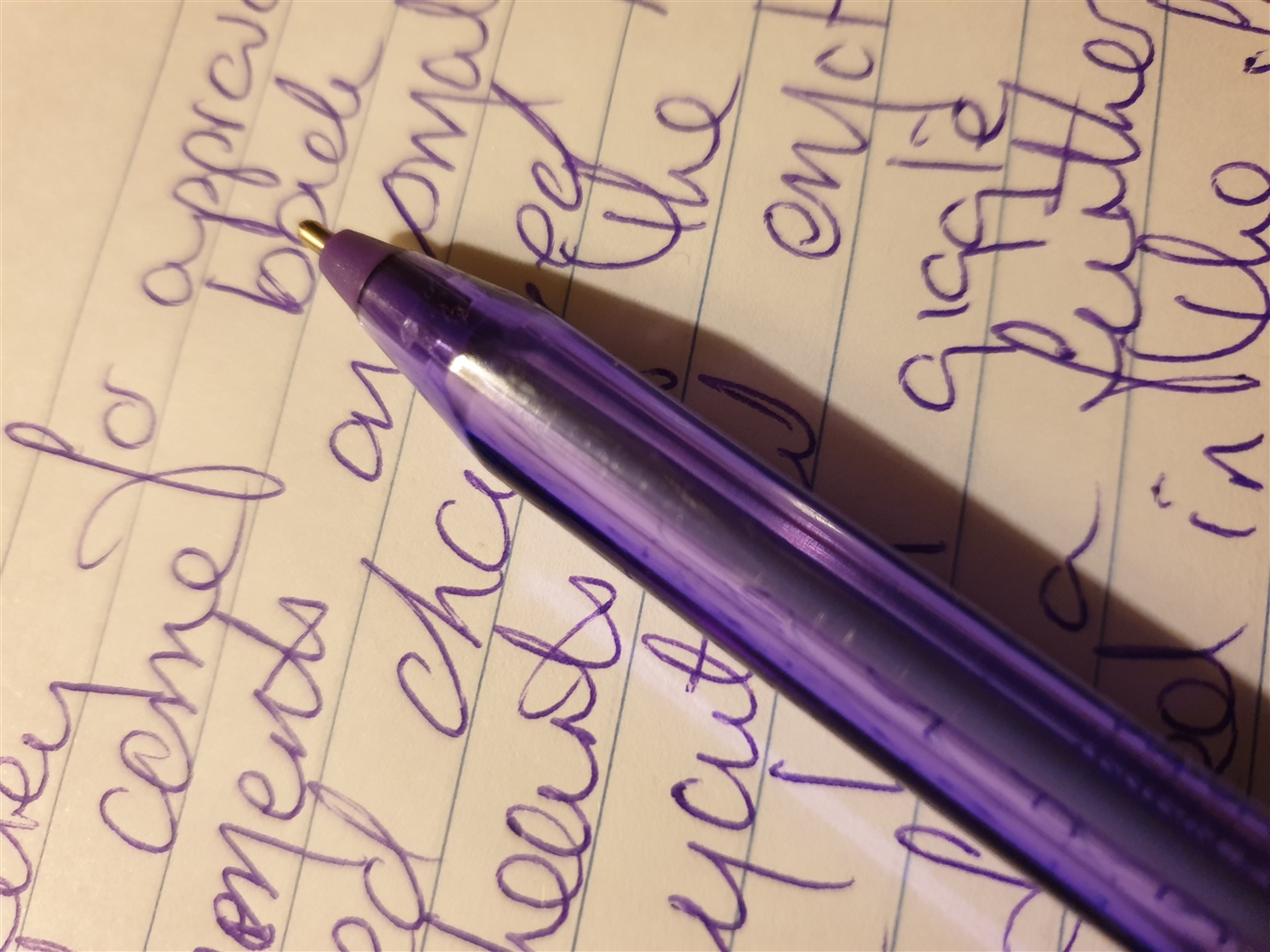 A blue pen resting on a lined notepad page, with lots of handwritten notes.