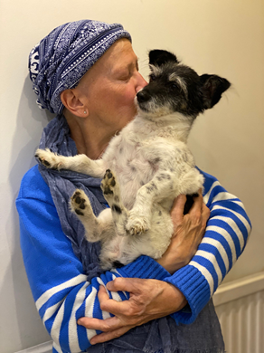 A woman wearing a headscarf holding a dog