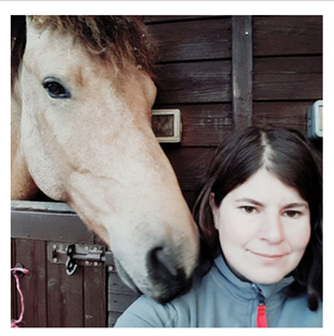A picture of Ginajsy with a horse. Ginajsy has brown hair and brown eyes.