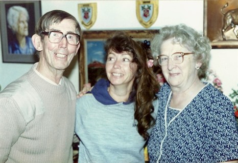  Photograph of Willo's dad on the left, Willo in the middle and Willo's mother on the right. All are smiling, and Willo is looking at her father.