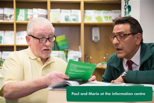 This image shows a photo of Paul and Mario together in an information centre. 