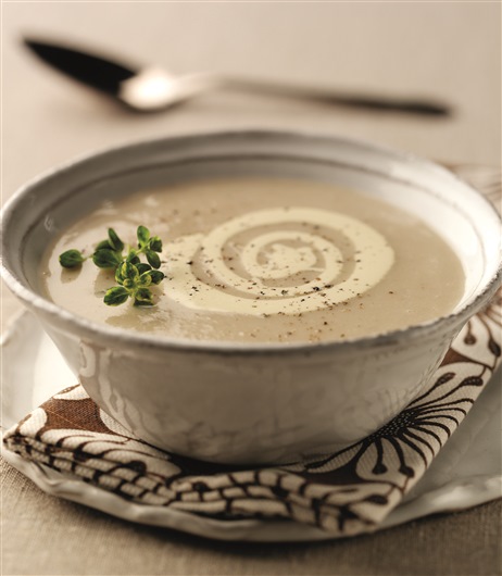 This image shows a bowl of coconut and parsnip soup. It is creamy brown in colour. 