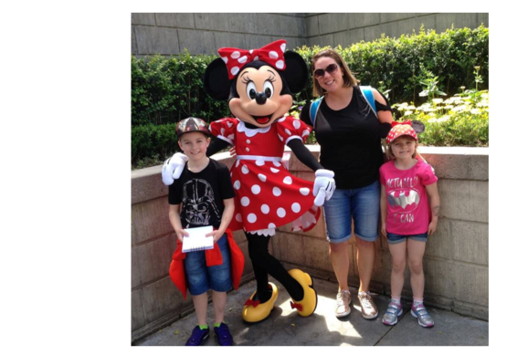  A photograph of Natalie and her two children with Minnie Mouse, all smiling at the camera.