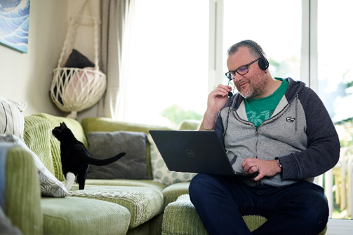 Person using a laptop whilst on the phone 