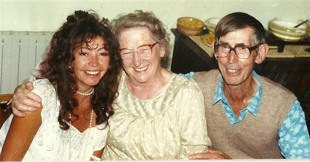 Photo of Willo with her mum and dad sitting side by side and all smiling happily into the camera 