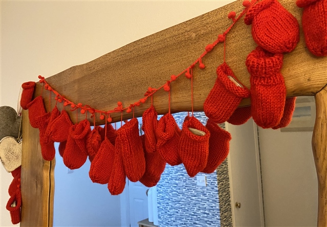 A string of knitted mittens as decoration.