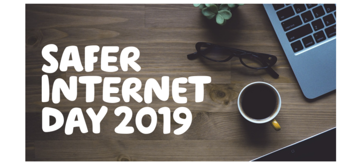  'Safer internet day 2019' written over a wooden desk with a laptop, plant, black glasses and a cup of coffee.
