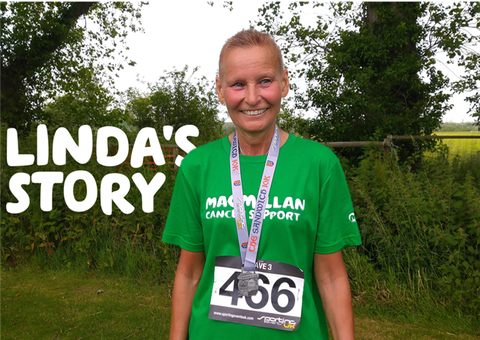 Linda is smiling in a green Macmillan t shirt and wearing a medal for running.