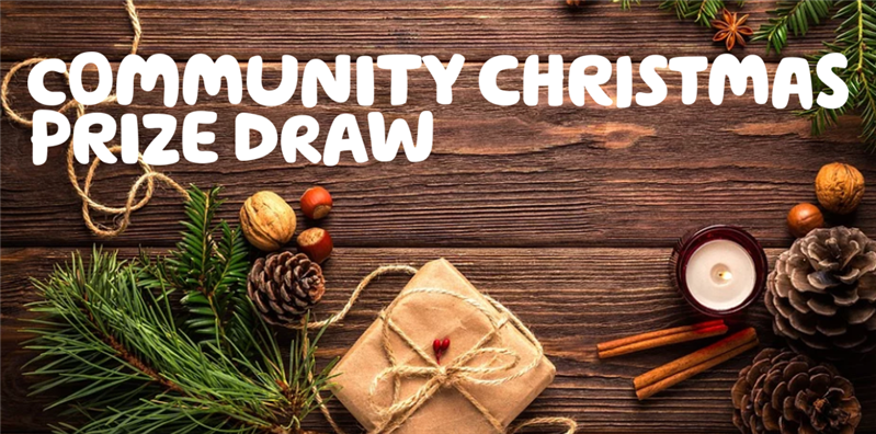  'Community Christmas Prize Draw' written in white over a festive image of Christmas aromaticsof a 