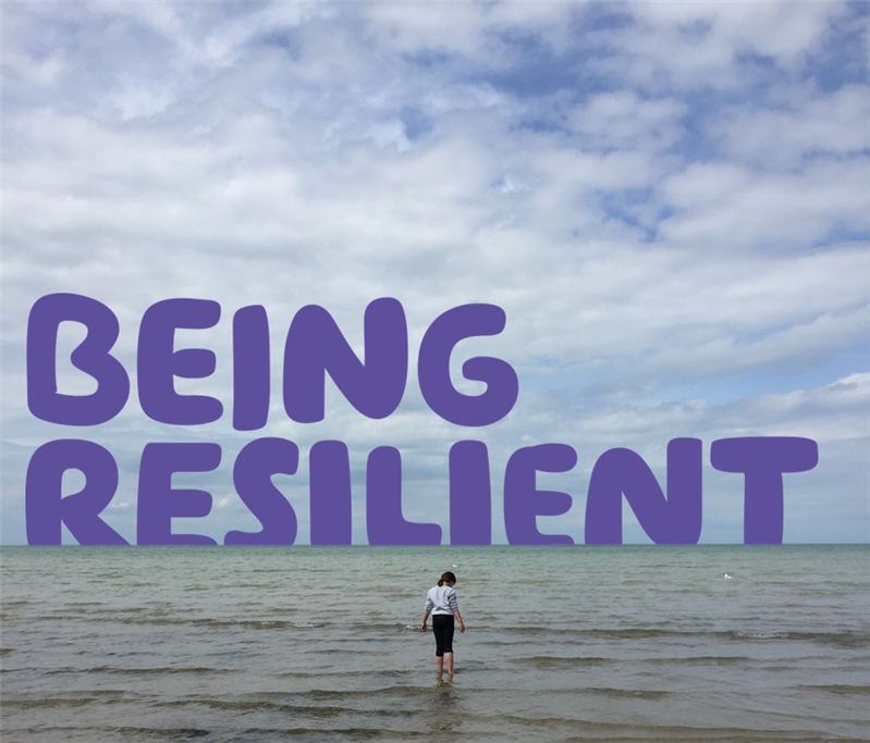 "Being resilient" written over a picture of a woman facing away from the camera, paddling in the sea under a blue sky. 