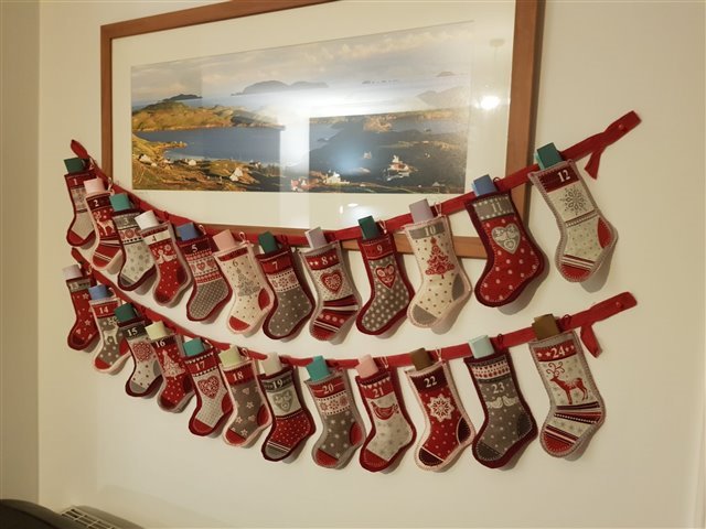 A homemade advent calendar, which is a string of small handmade red and white stockings.