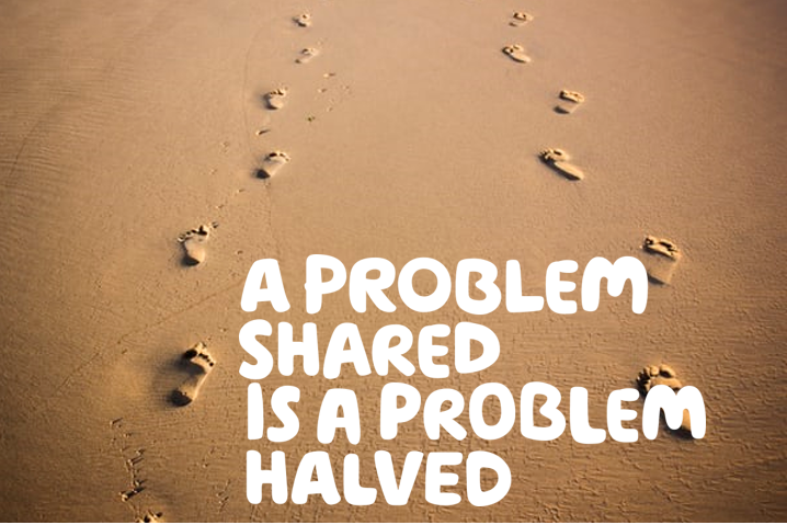 White text saying a problem shared is a problem halved on a picture of footprints in the sand moving forward. 